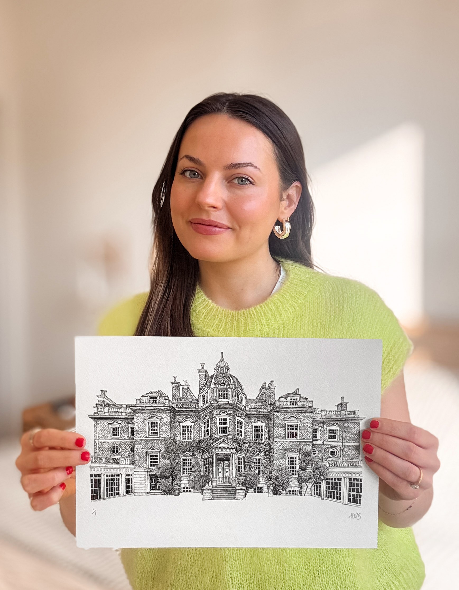 Architectural illustrator, Nushy, holding one of her fineliner venue illustrations