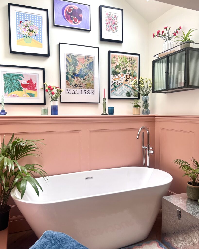 A bathroom designed by Becks from The Interior Lens, with soft muted pink paneling, a standalone bath, and touches of colour from plants to artwork