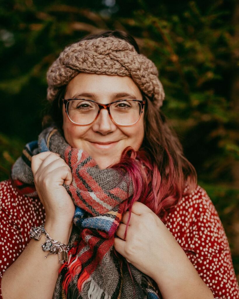 Lou from Tea and Crochet outside, wearing one of her crochet ear-warmers