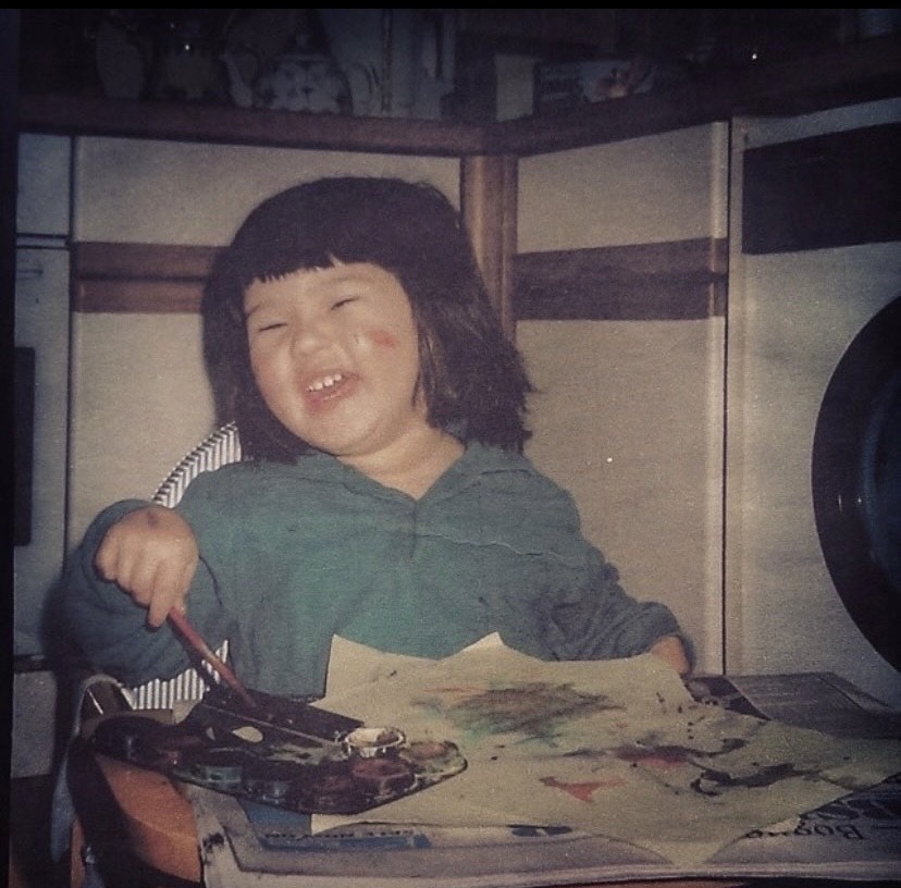 Charlotte from Cloth and Clay as a child, painting in her high chair