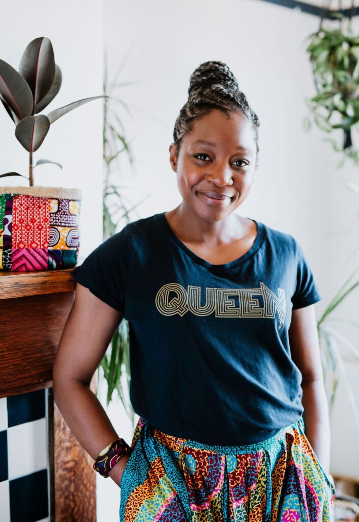 Chantel from Mashona Designs wearing a black t-shirt with the text "Queen", and African textile trousers