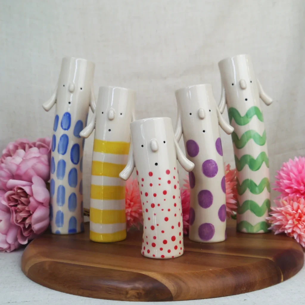 Characterful vases by Millie's Ceramics with little faces and arms