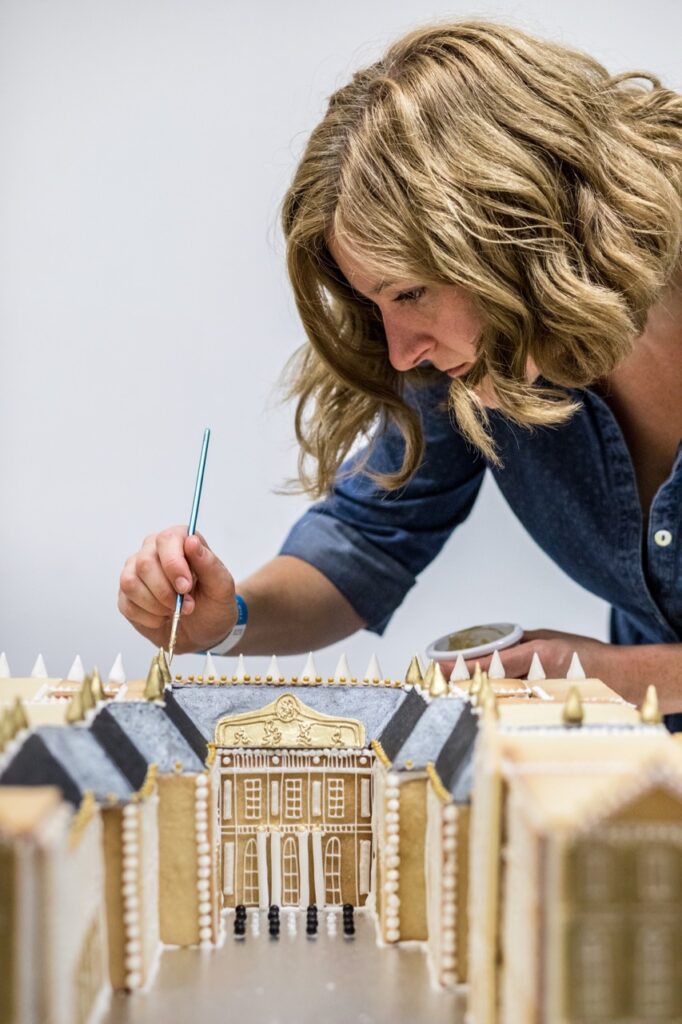Emily Garland putting the finishing touches on one of her architectural gingerbread builds