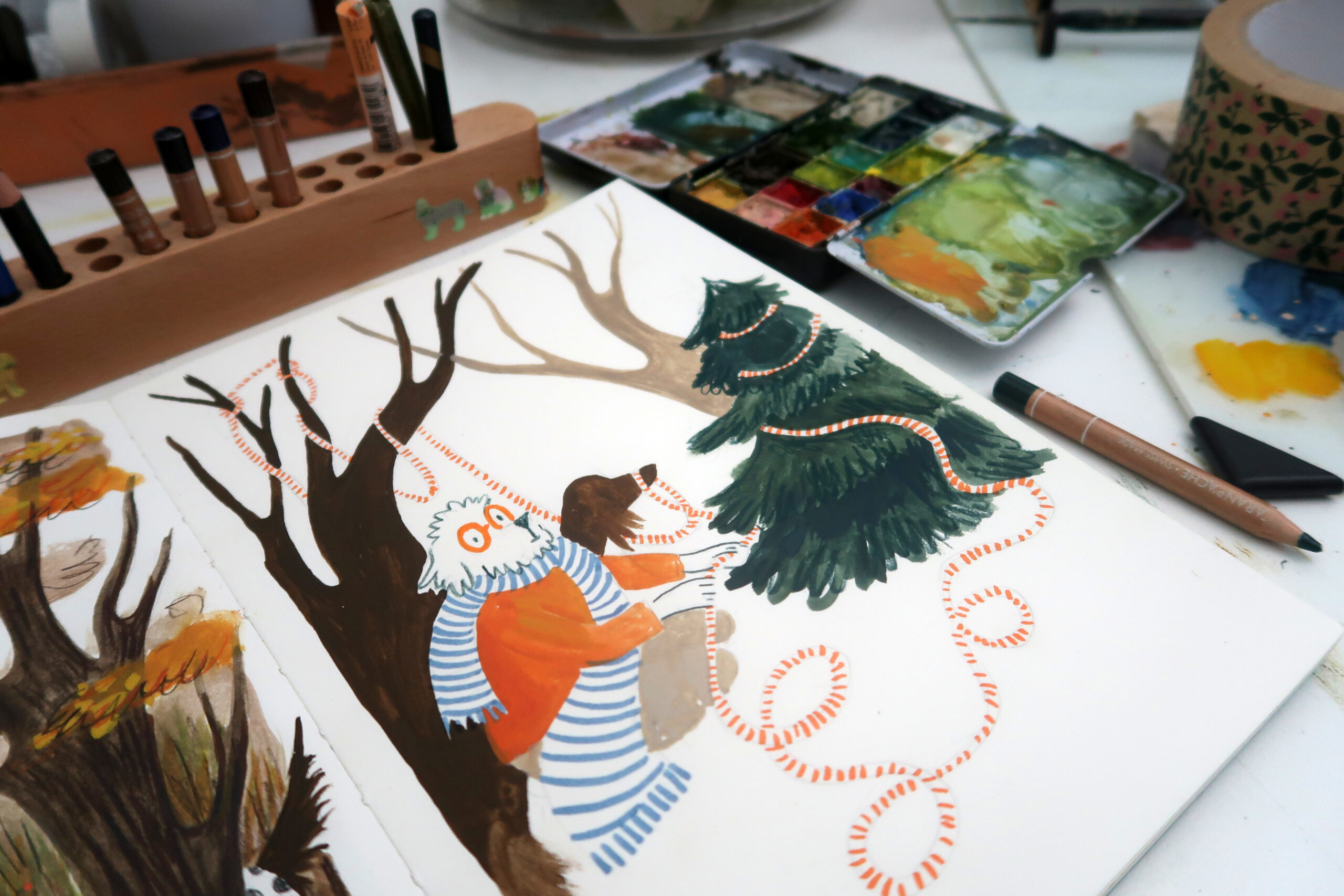 Arati Devasher's sketchbook open with an illustration of an anthropomorphic dog in a scarf, with trees behind