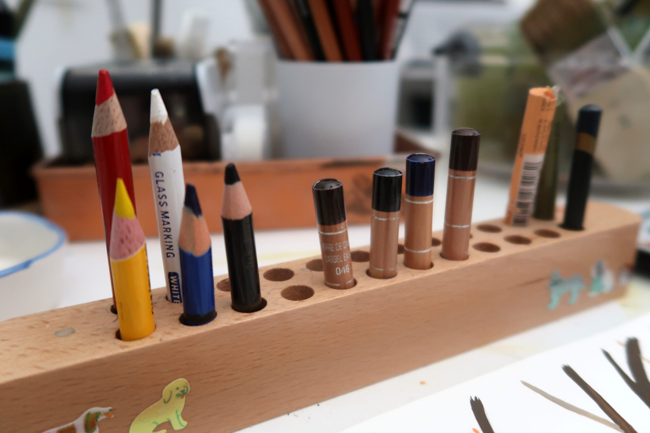 A wooden stand with well used art pencils on Arati Devasher's desk