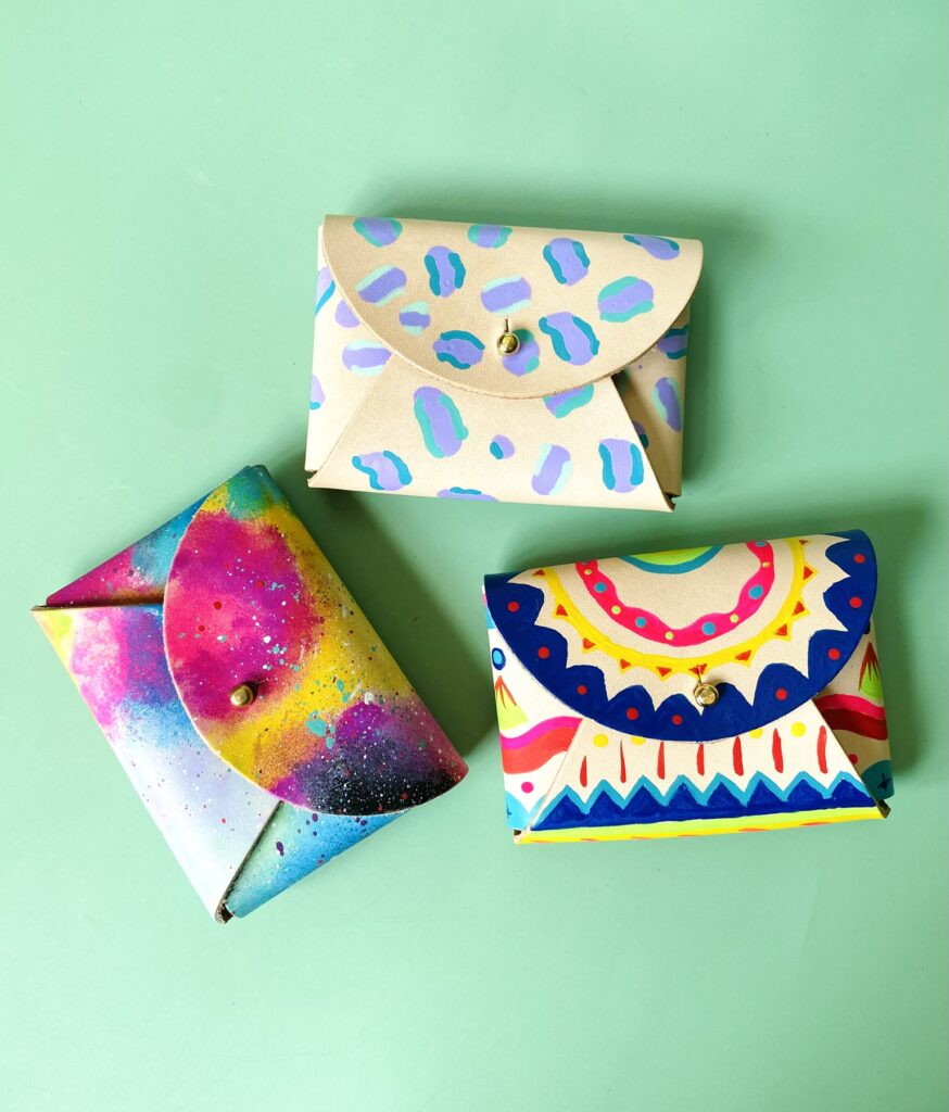 Three examples of the colourful creations you can make using the leather purse painting kit by Willow Leather - with designs from cosmic rainbows to fun patterns