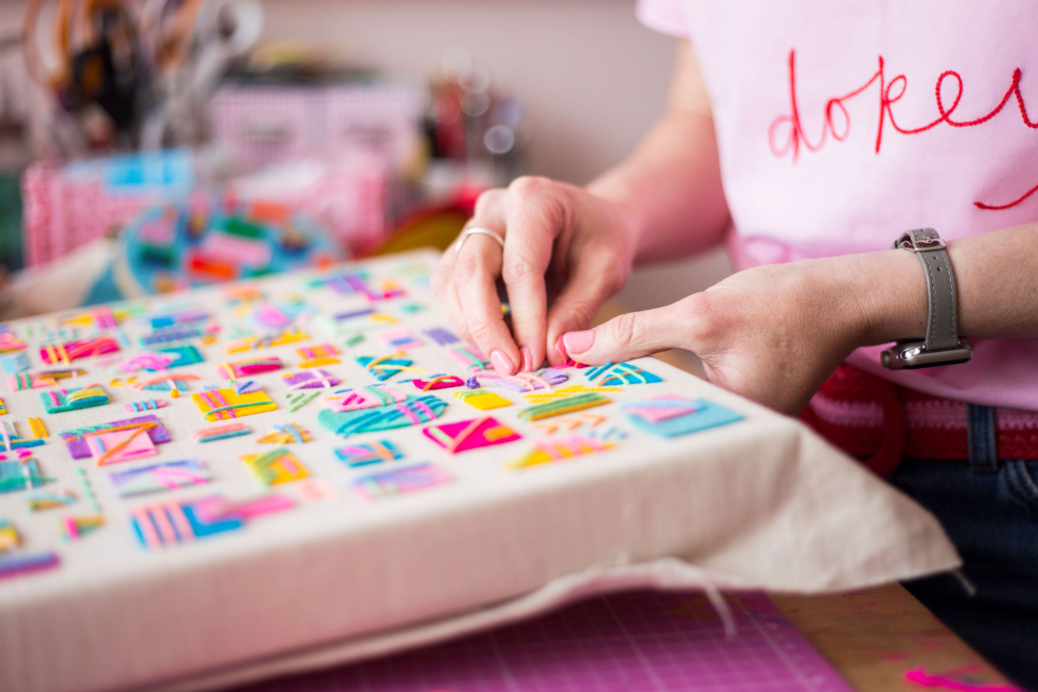 A brand photo by Lucy Hannah Photography, showing a woman's hands sewing an abstract and colourful embroidery piece