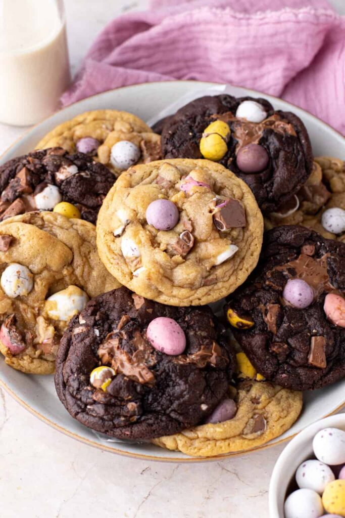 Mini egg cookies by Jessie Bakes Cakes, stacked on a plate with a glass of milk in the background