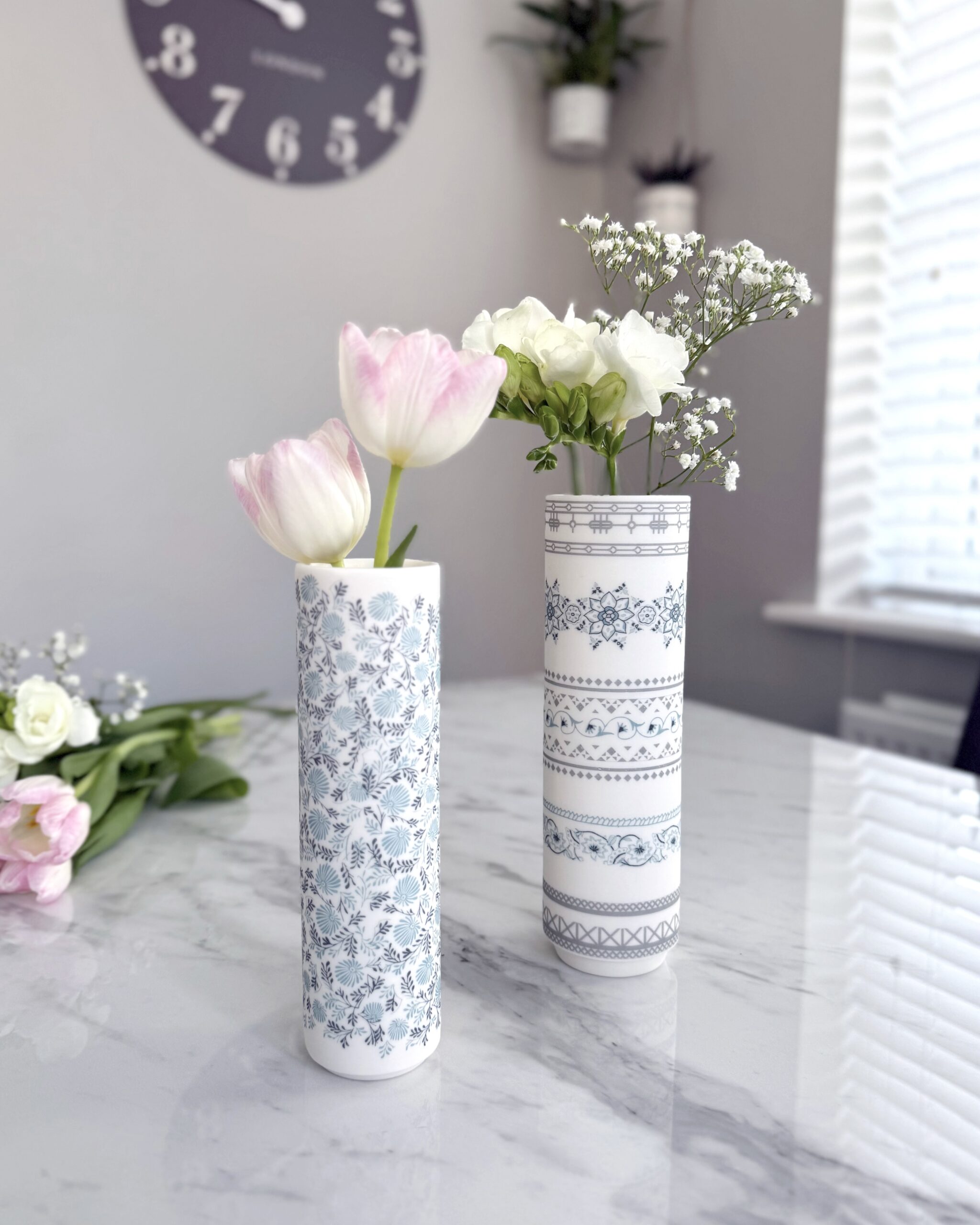 White ceramic flower vases with intricate blue surface pattern design, by Alex Allday